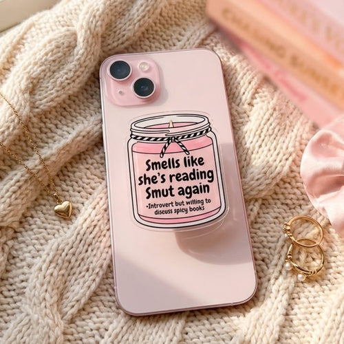 The Bookish Grip on a pink iPhone beside a book stack
